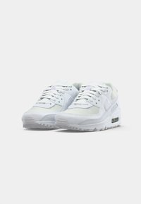 White athletic shoes with a mesh and leather upper, round toe, flat lace closure, and a visible air sole unit in the heel.