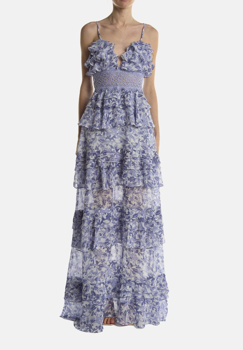 Vestido maxi en azul claro con estampados florales. Presenta tirantes con volantes, un corpiño ajustado y una tela translúcida en capas que fluye hasta el suelo.