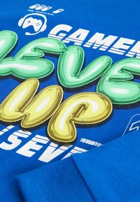 Kék kapucnis pulóver, rajta zöld és sárga fényes buborékbetűkkel a "Level Up" felirattal, gamer grafikákkal és texturált anyag részletekkel.
