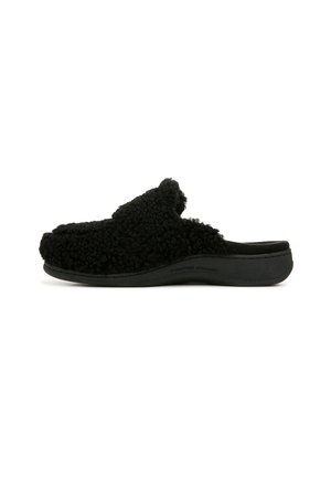 Schwarzer Slip-On-Hausschuh mit weichem, lockigem Obermaterial und stützender Sohle, als podologenentwickelt gekennzeichnet.