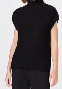 Svart mock turtleneck strikkad topp med korta ärmar, med ribbat mönster och vertikal detalj, utformad för en löst sittande passform.