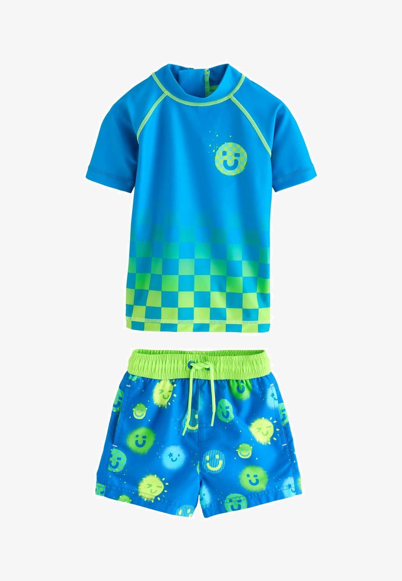 Sinine lühikeste varrukatega rash guard rohelise ruudulise mustriga ja naeratava näo logoga, koos siniste ujumishortuudega, millel on erksad naeratava näo motiivid.