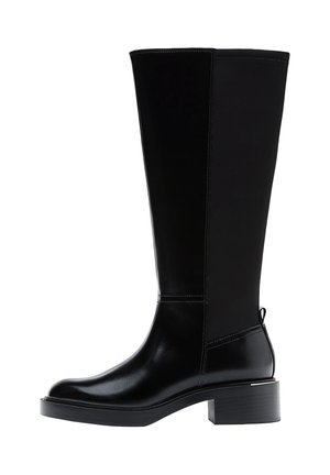 Botte haute noire en cuir et tissu avec un talon bloc bas et un onglet à l'arrière, vue de l'extérieur.