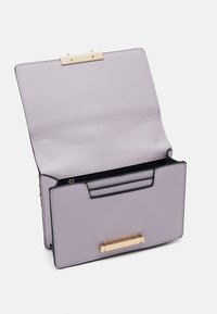Borsa a tracolla sintetica viola con una texture liscia, dettagli in oro, chiusura magnetica e scomparti interni per carte. Il design con apertura superiore rivela il compartimento principale.