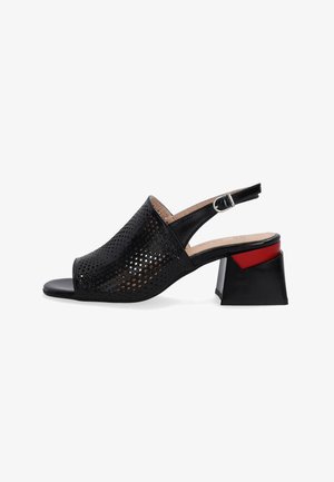 Schwarzer, perforierter Slingback-Schuh mit offener Zehe, ausgestattet mit einem niedrigen Blockabsatz mit rotem Akzent und einem Schnallenverschluss.