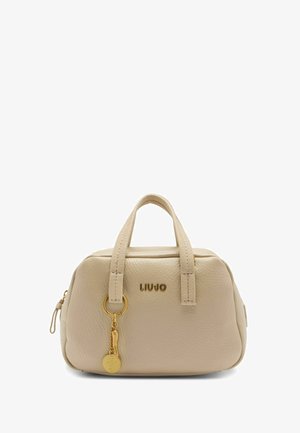 Beige læderhåndtaske med guld hardware, rund form, to håndtag og en charme hængende fra en løkke, der bærer mærkenavnet "LIUJO."