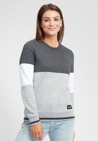 Felpa color block grigia e bianca con colletto rotondo, maniche lunghe e strisce nere a contrasto sui polsini e sull'orlo. Etichetta del marchio nella parte inferiore.