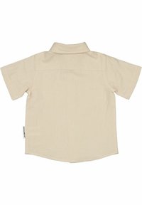 Beige kortärmad skjorta med en mjuk textur, en notad krage och en rundad fåll. Har en liten märkesetikett på sidan av sömmen.