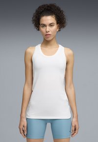 Άσπλο αθλητικό τοπ με λαιμόκοψη στρογγυλή και σχέδιο racerback, κατασκευασμένο από λείο ύφασμα. Διαθέτει διακριτικό λογότυπο της μάρκας στο στήθος.