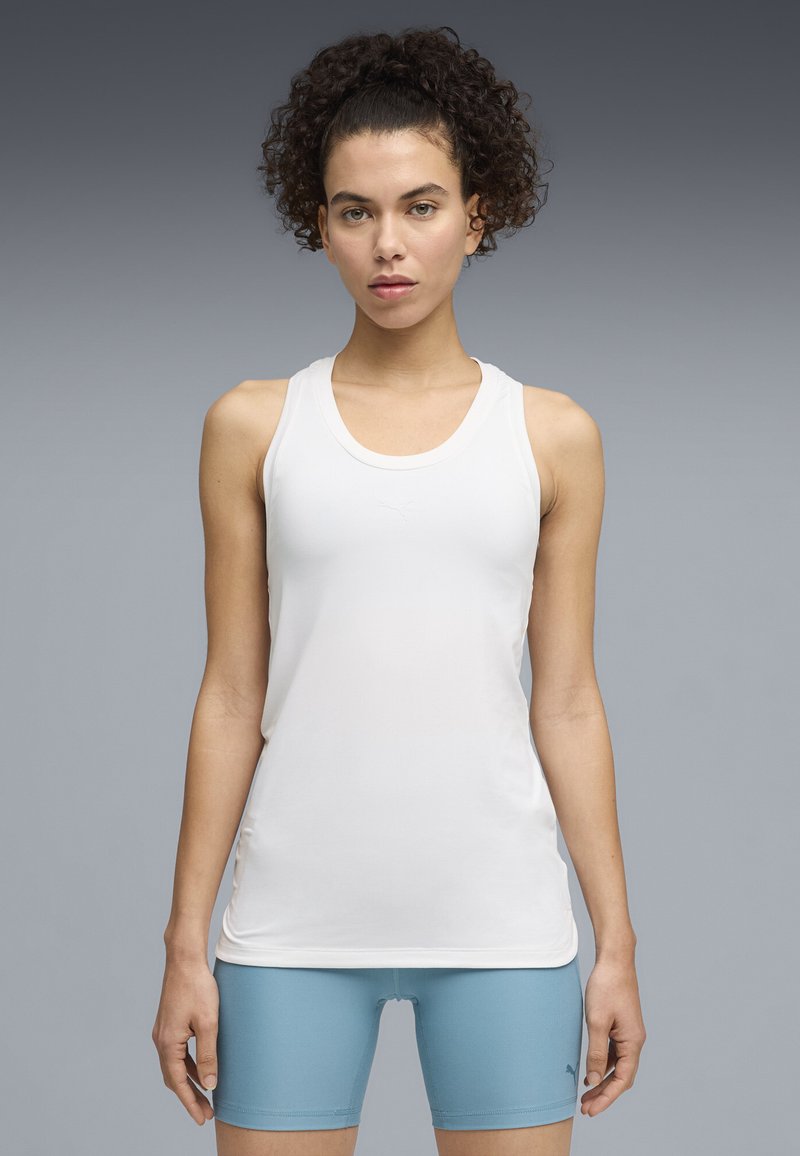 Άσπλο αθλητικό τοπ με λαιμόκοψη στρογγυλή και σχέδιο racerback, κατασκευασμένο από λείο ύφασμα. Διαθέτει διακριτικό λογότυπο της μάρκας στο στήθος.