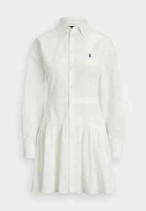 Fehér gombos ingruha hosszú ujjakkal, ráncolt szoknyával és szabott derékkal. A mellrészen egy apró sötétkék logó található.