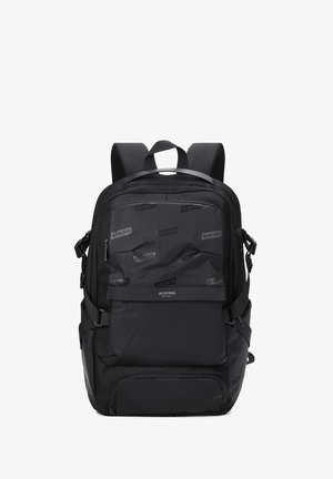 Zaino nero con pannelli texturizzati e accenti lisci. Presenta spallacci regolabili, molteplici scomparti con zip e base rinforzata.