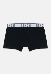 Boxer-briefs noirs pour hommes avec une taille blanche portant le mot "BENCH" en lettres noires espacées.