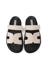 Infradito neri con una fascia beige testurizzata caratterizzata da un design con fori. Hanno una soletta imbottita e una suola in gomma flessibile.