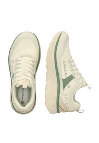 Helle beige Sportschuhe mit einem strukturierten Mesh-Obermaterial, grünen Akzenten, gedämpfter Sohle und abgerundetem Zeh. Mit Schnürsenkeln und Logodetails.