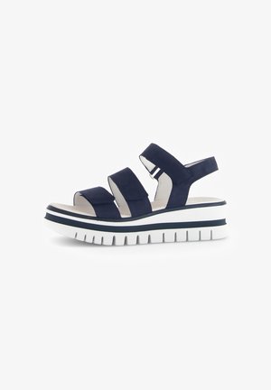 Marineblauwe platform sandalen met drie brede banden en een gesloten achterkant, met een witte en marineblauwe gestreepte zool met een gestructureerde loopzool.
