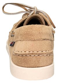 Beige mokkasiinimallinen kengät, joissa on pyöreä kärki, erottuva ommel ja teksturoitu pinta. Takana on nauhasidonta.