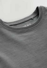 Graues T-Shirt mit Rundhalsausschnitt, gestickten Details und einer weichen, glatten Textur. Markenlabel im Kragen sichtbar.