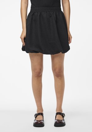 Jupe minime texturée noire avec une taille élastique. Présente une forme évasée et décontractée qui tombe au-dessus de mi-cuisse.