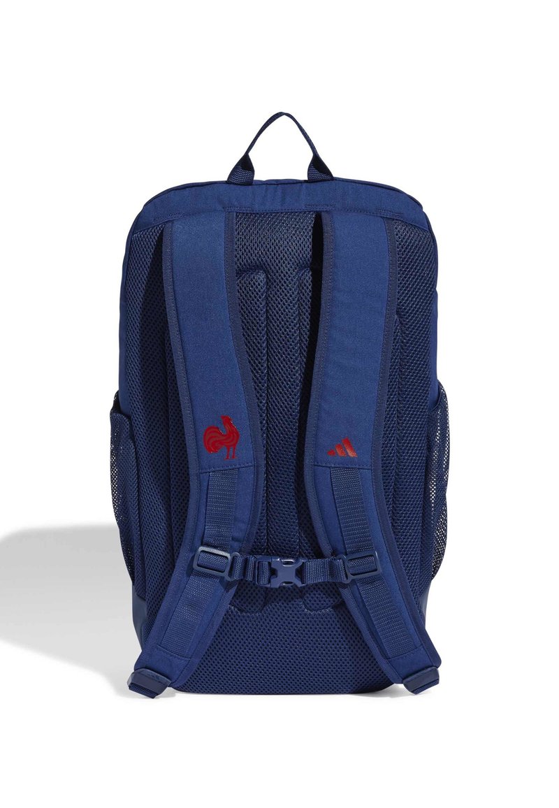 Dunkelblauer Rucksack mit Netzpanelen, verstellbaren Schultergurten und einer Seitentasche. Mit Akzenten des roten Hahns und des Adidas-Logos.