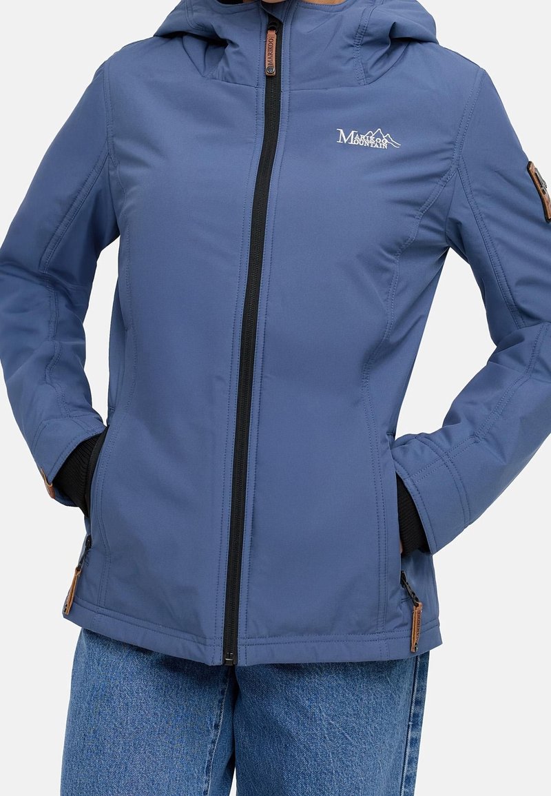 Veste d'extérieur bleue à fermeture éclair avec capuche, poches latérales et fermeture éclair noire, portée par-dessus des gants noirs et associée à un jean bleu.