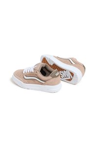 Beige semišové tenisky s bílými tkaničkami a kontrastní hnědou koženou patou, s bílou podrážkou a logem Vans na boku a ve spodní části.