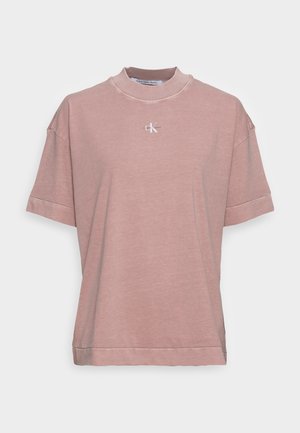Różowy t-shirt Calvin Klein Jeans z krótkim rękawem, ze stójką i małym białym logo CK na środku klatki piersiowej.
