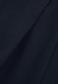 Tela azul marino oscuro con textura suave y un pliegue diagonal que crea una sombra sutil en la superficie.