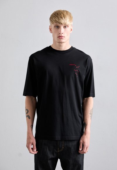 Schwarzes Baumwoll-T-Shirt mit kurzen Ärmeln, ausgestattet mit einem roten Logo-Design auf der Brust. Einfache, lässige Passform mit glatter Textur.
