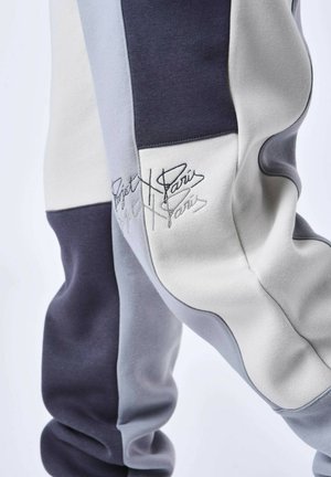 Pantalons de survêtement en coloris gris, marine et blanc en coton. Dotés d'un détail de logo brodé et d'une finition douce et texturée.