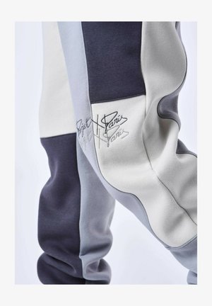 Kleurenblokken joggingbroek in grijs, marineblauw en wit katoen. Bevat geborduurd logo-detail en een zachte, textuurafwerking.