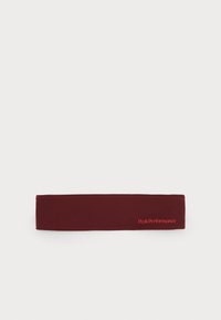 Burgundy headband made of soft fabric, featuring a flat design. Displays "PeakPerformance" in bright red on one side. Simple and seamless.