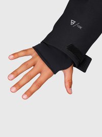 Mano con una manga negra con agujero para el pulgar y correa ajustable en la muñeca, mostrando la marca "10K" en la tela.