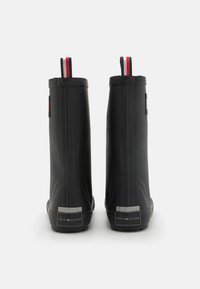 Bottes de cheville en caoutchouc noir avec une finition lisse, dotées d'une languette en tissu rayé et d'un accent de talon estampillé. Semelle renforcée pour plus de durabilité.
