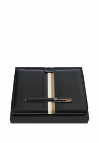 Folio en cuir noir zippé avec des rayures verticales beiges et blanches, marqué "BOSS", avec un stylo assorti noir et doré posé dessus.
