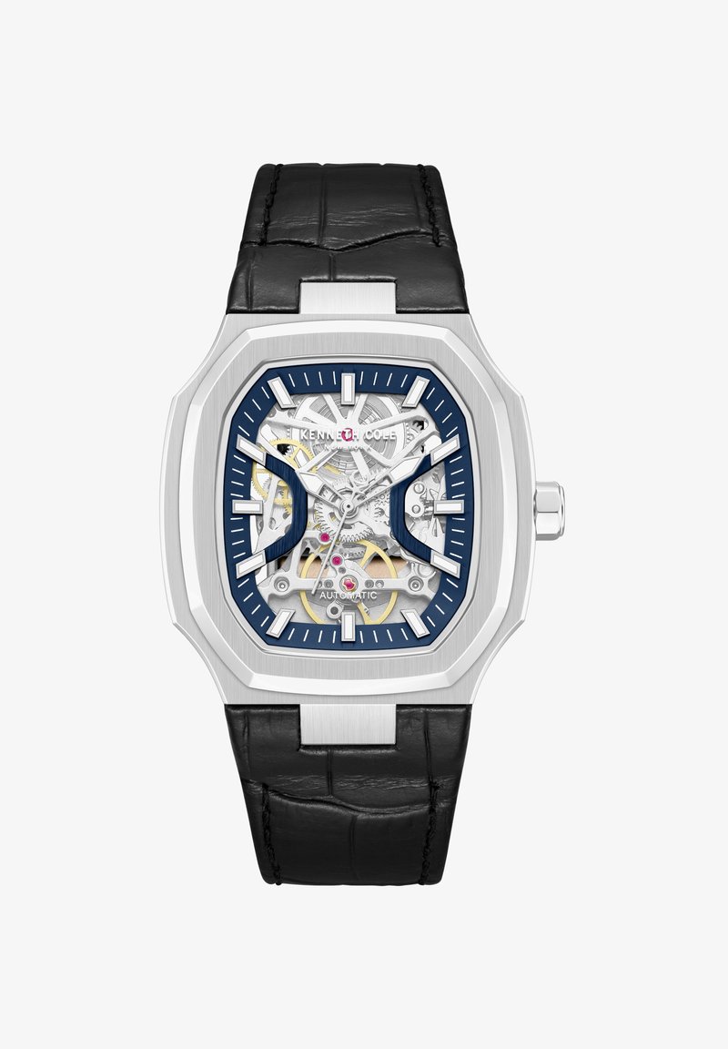 Orologio automatico scheletro da uomo in tono argento con cinturino in pelle nera, accenti blu, ingranaggi visibili e cassa rettangolare in acciaio inossidabile.