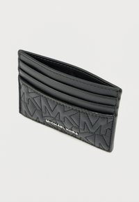 Čierny kožený držiteľ kariet s viacerými priehradkami na karty, prešívanou textúrou a vyrazenými logami. Kompaktný, minimalistický dizajn so strieborným logom.