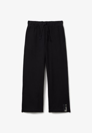 Black sweatpants made from a soft material, featuring an elastic waistband with a drawstring, side slits at the hem, and a logo tag on the bottom.