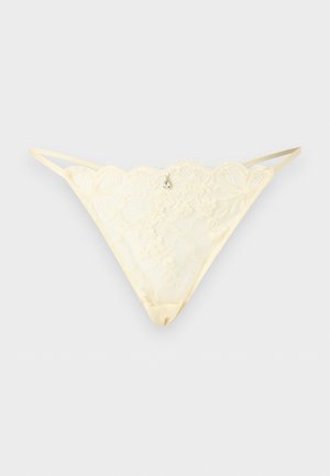 Ivory lace thong underwear with floral pattern, thin elastic side straps, and small decorative gem at the center front.