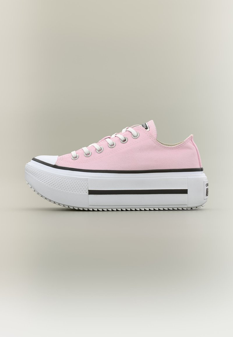 Ροζ πάνινο αθλητικό παπούτσι χαμηλού ύψους με χοντρή λευκή σόλα, λευκή προστασία δαχτύλων, λευκά κορδόνια και μαύρη ρίγα στη σόλα.