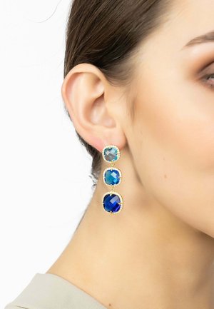 Gold-tone drop earrings featuring three stacked, rectangular stones in varying shades of blue. Each stone has a faceted surface and a detailed bezel.