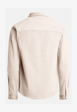 Long-sleeve shirt in beige textured fabric, featuring a collar, buttoned cuffs, and a curved hem with a center yoke at the back.