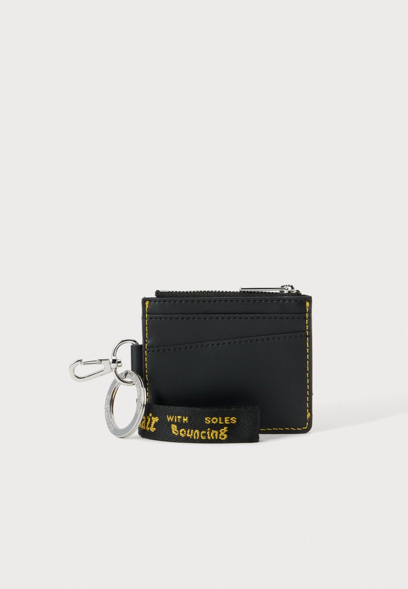 Porte-cartes noir avec des coutures jaunes, une poche zippée et un porte-clés attaché avec une sangle en tissu noire et jaune.