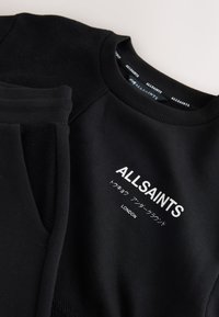 Czarna bluza z prążkowanym kołnierzem i rękawami z białym logo ALLSAINTS, japońskim tekstem i nadrukiem "LONDON" na piersi.