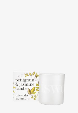 Biały ceramiczny holder na świece z wyraźnym napisem, obok pudełka w kwiatowy wzór w kolorach zielonym, żółtym i białym. Zawiera zapach petitgrain i jaśminu.