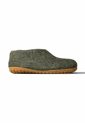 Gesloten grijze vilten pantoffel met een geribbelde beige rubberen zool, ontworpen voor comfort en grip binnenshuis, getoond vanaf de zijkant op een witte achtergrond.