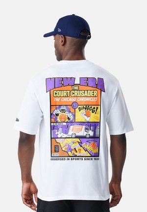 Hombre con camiseta blanca con gráficos de baloncesto estilo cómic coloridos y texto "New Era The Court Crusader The Chicago Chronicles" en la espalda.