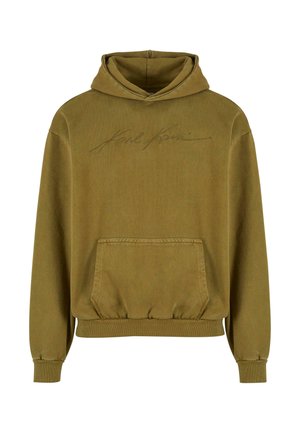 Zaļa kapuce ar priekšējo kabatu, ar izšuvumu logo un ribotām piedurknēm. Izgatavota no mīksta kokvilnas auduma, tai ir brīvs griezums.