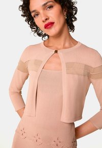 Staubrosa gestrickte Strickjacke mit Dreiviertel-Ärmeln, rundem Ausschnitt und goldener Hardware-Verschluss. Geschichtetes Design mit transparenten Akzenten.