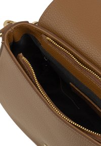 Bruine leren schoudertas met textuur en gouden hardware, met één hoofdcompartiment en twee ritszakken binnenin.